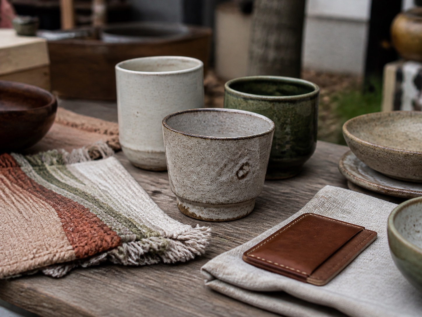 AI-generated placeholder showing handmade ceramics, textiles and leather goods on a wooden table